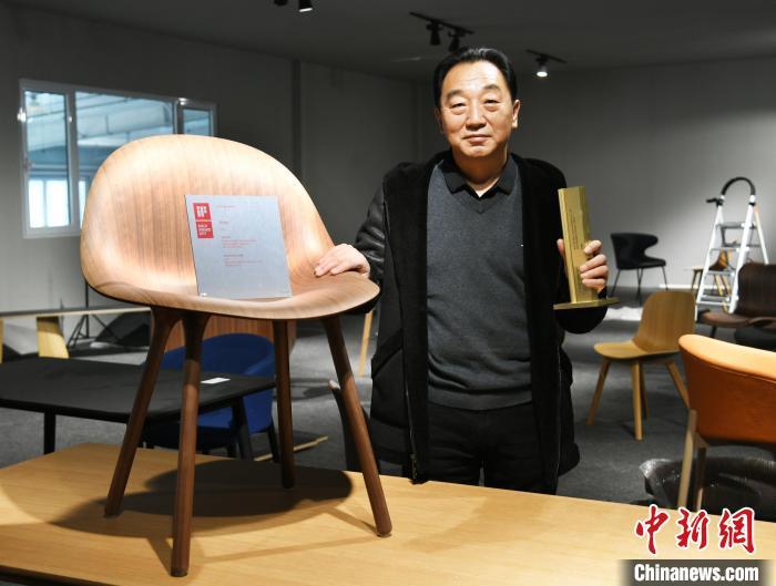 圖為產(chǎn)業(yè)園內(nèi)的一家公司負(fù)責(zé)人展示獲得德國IF設(shè)計(jì)金獎的椅子?！∷蚊魸?攝